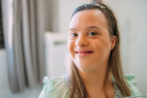 Close up portrait of smiling woman with down syndrome at Special Care Dentistry of Oregon in Albany, OR